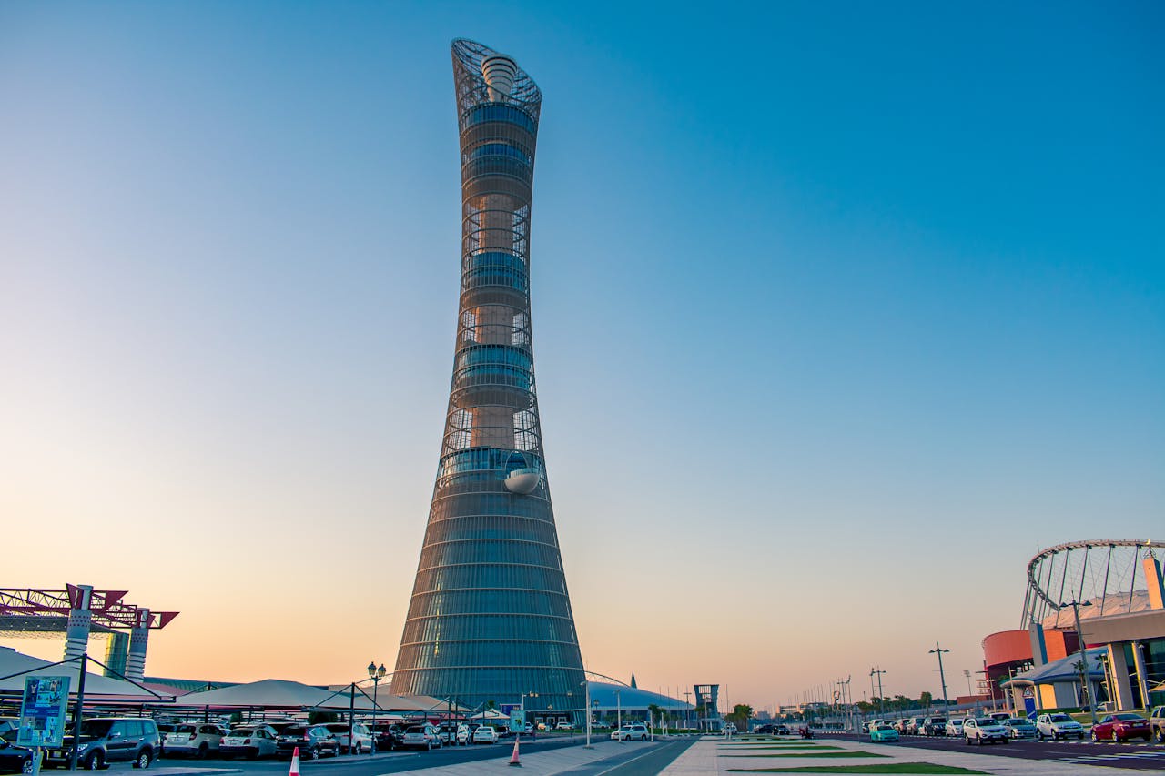 contact-img Aspire Tower in Doha stands tall against a clear sky, showcasing modern architecture.