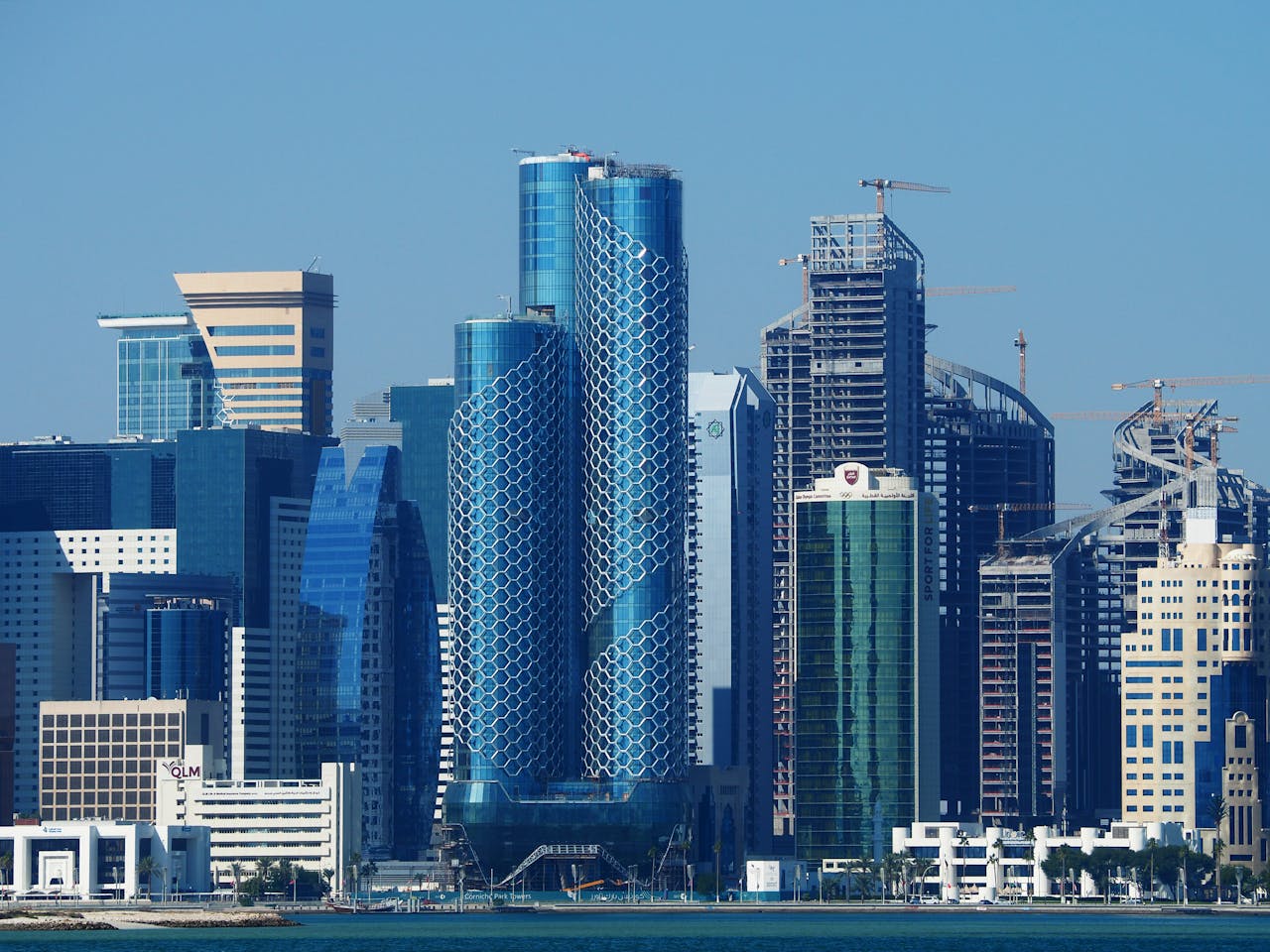 services-02 Explore the futuristic skyline of Doha, showcasing modern architectural designs and towering skyscrapers.