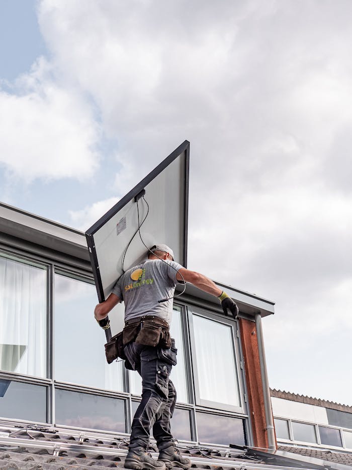 ours-journey A worker installs a solar panel on a residential rooftop emphasizing renewable energy.